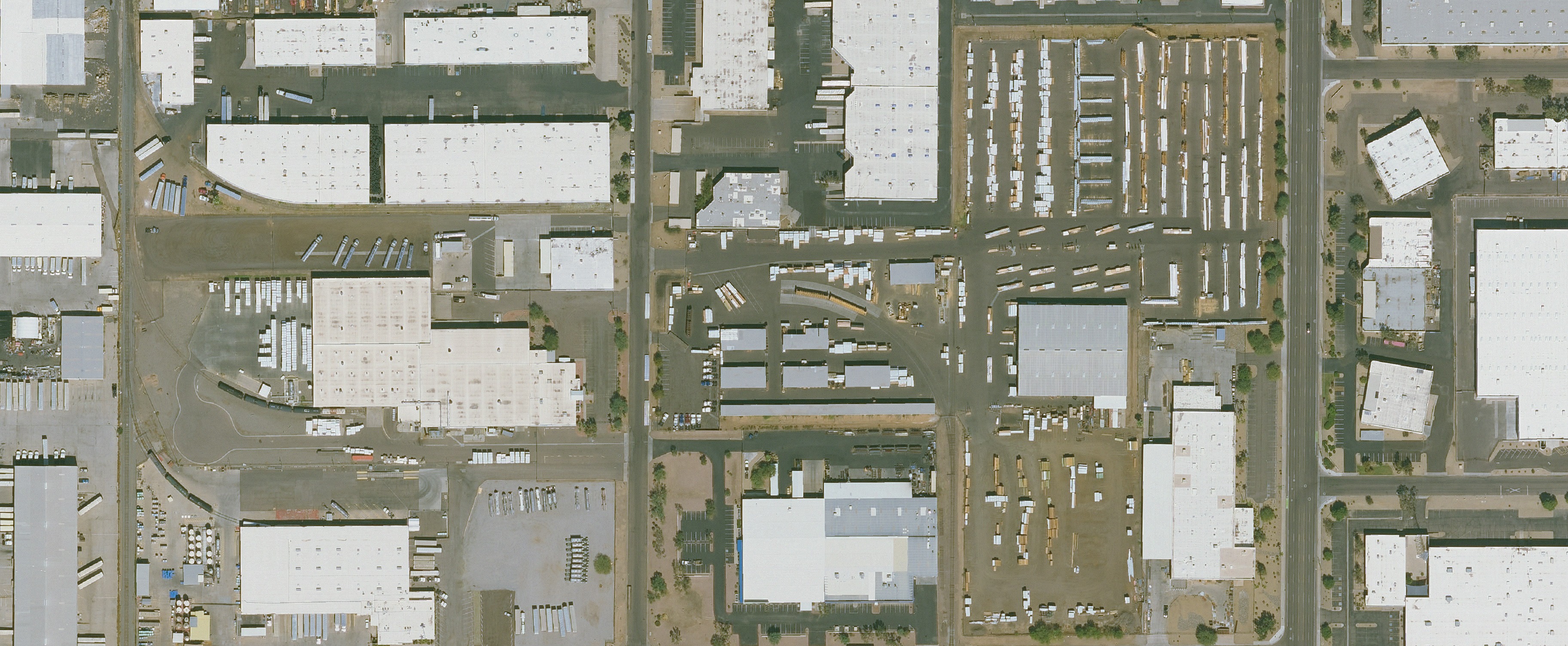 Wide public-domain aerial view of a working lumberyard and its surrounding operating area. The location is not identified.